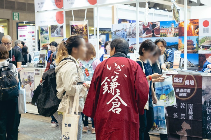 写真：来場者と歓談する地域の担当者